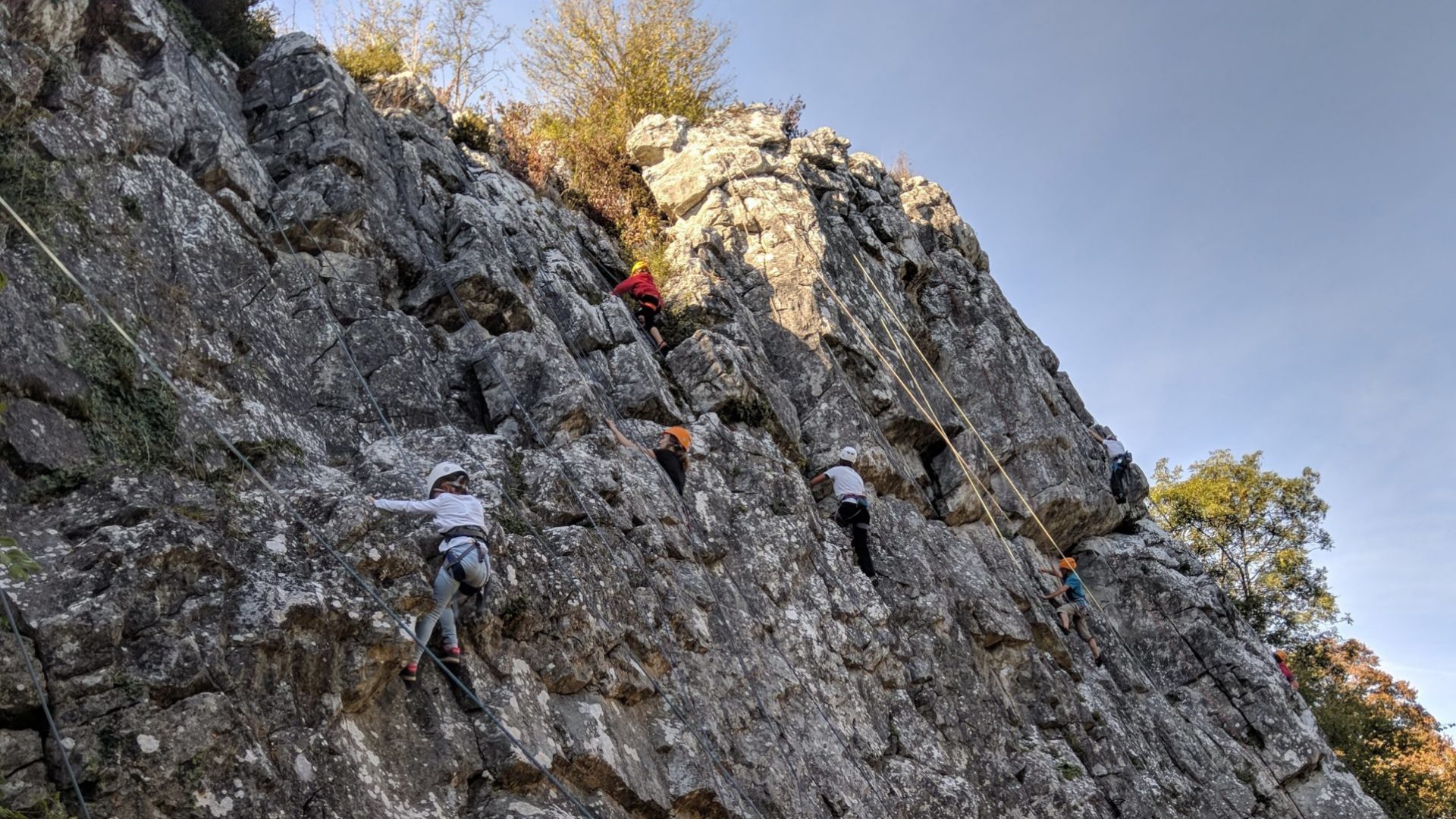 Des jeunes apprennent l'escalade sur une paroi rocheuse