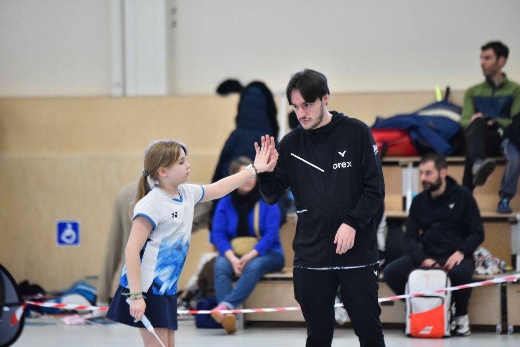 Un coache et sa jeune badiste se tapent dans la main avant de reprendre le match